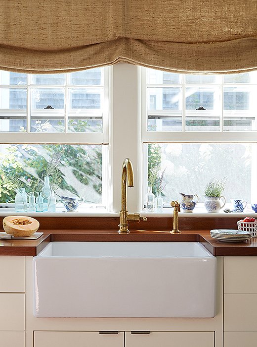 The coarse weave of the roman shade and the grain of the wooden counters add to the sink’s rustic vibe. Photo by Tara Dunne.
